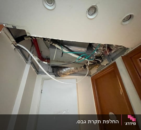 תקרת גבס עם צינורות וחוטים חשופים